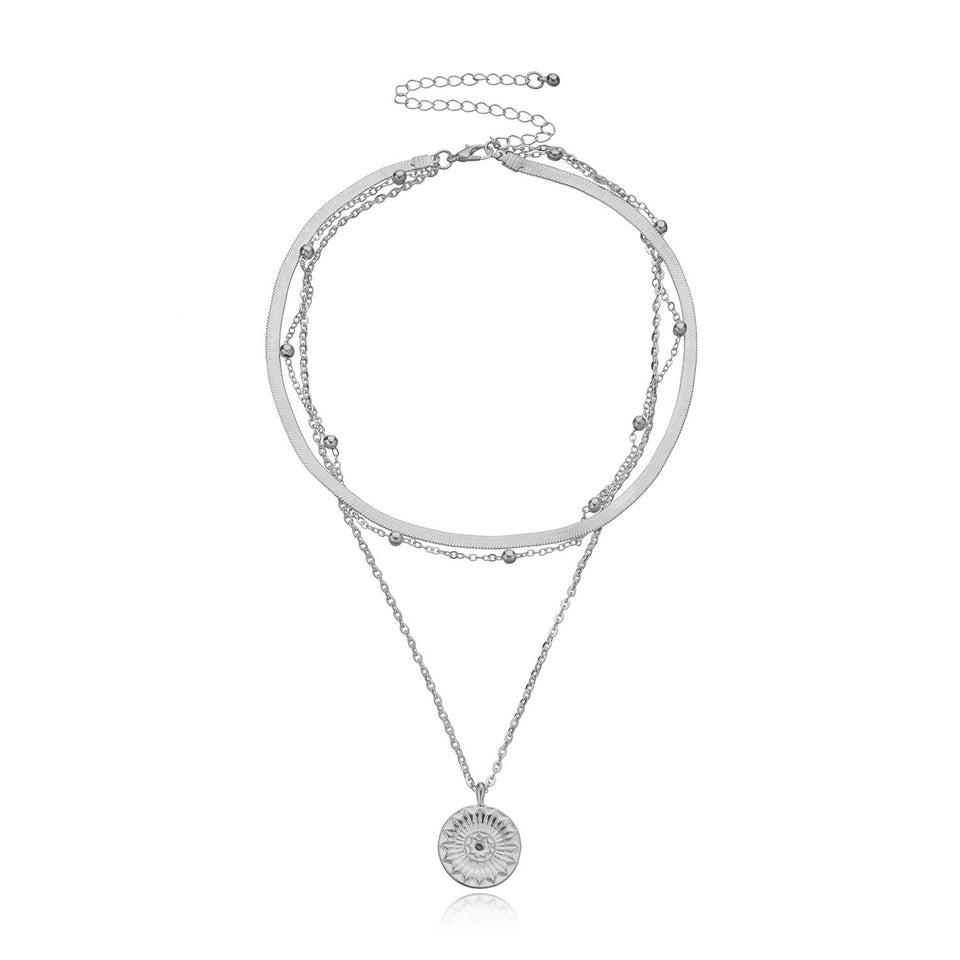 Lagerhalsband i guldfärg med mynt och berlocker