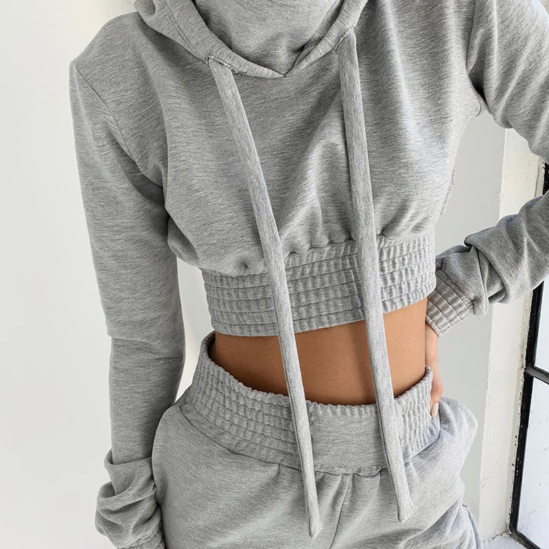 Grått mysset med kort hoodie och joggingbyxor