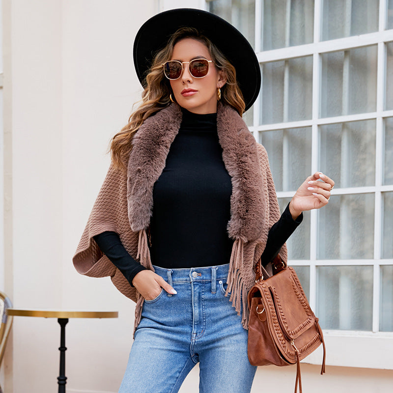 Stickad cape med fuskpälskrage och fransar