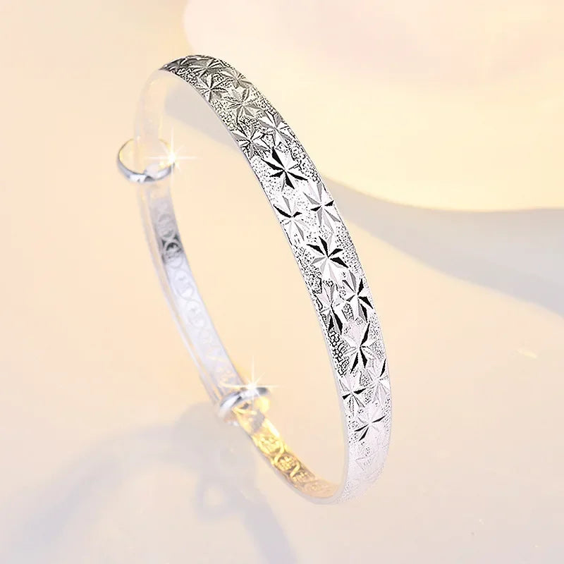 Silverfärgad armring med stjärnmönster