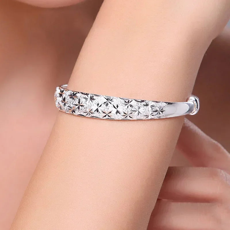 Silverfärgad armring med stjärnmönster