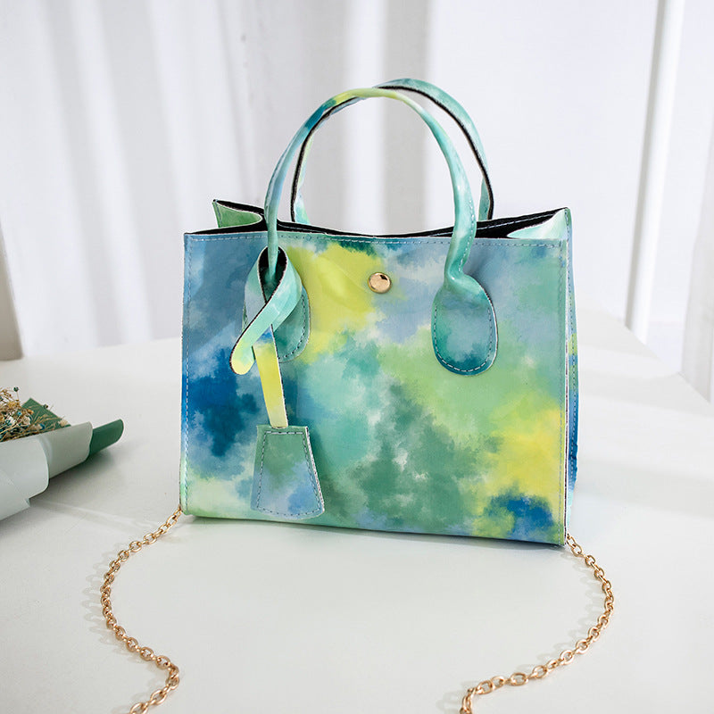 Lackad crossbody-väska med tryck och guldkedja