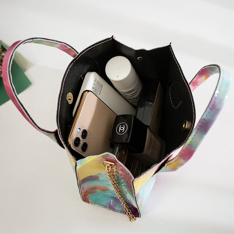 Lackad crossbody-väska med tryck och guldkedja