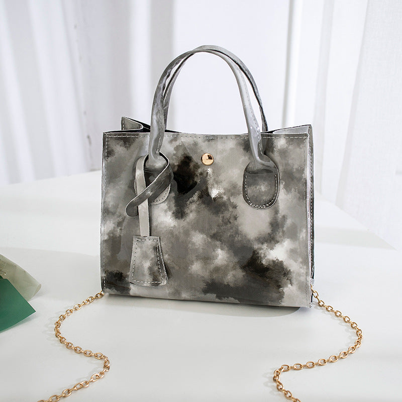 Lackad crossbody-väska med tryck och guldkedja