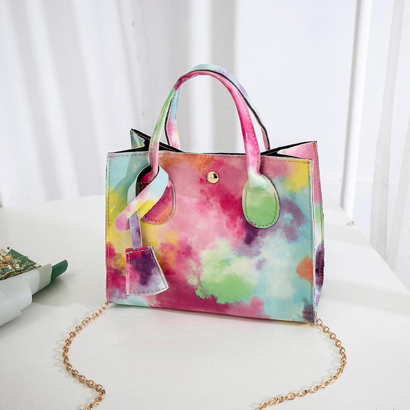 Lackad crossbody-väska med tryck och guldkedja
